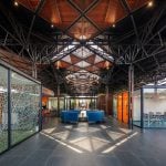 PROJECT INFORMATION Project Name: Experience Centre Location: Koyembedu, Chennai Site Area: 0.75 Acre Built-up Area: 0.20 Lac sft No of Floors: 1 Status: Completed Year of Completion:2021 Firm: CnT Architects Design Team (CnT): Amit Rastogi, Karthik P Nair, Anupama Rao Consultants: Metal Queen (Structure), Mukund Associates (Plumbing), Lite Lab (Lighting Design), Oikos (Landscape), Graphics Beyond (Graphic Design) Photography: Andre Fanthome INTRO (470 Words) Located in Chennai metropolitan at a close proximity to city’s transit hub, the site is approached from a highly buzzing Poonamalli high road. Three key components- A marketing office, an Experience centre and a Construction site office are the core of the facility. ‘‘Journey through the project reveals intricately detailed spatial sequences carefully crafted by the thoughtful blend of Architecture, Landscape and Interior design. Visual frames and experiences unfold in layers to keep the visitor captivated & intrigued throughout.’’ A landscaped plaza creating a tranquil arrival experience is first on the entry sequence; doubling up as the interface between city and the main program filtering the unwanted external buzz. At point of arrival, one gets a glimpse of Intricate roof canopy of marketing office hovering over plaza feature wall, creating a sense of mystery for what lies ahead. ‘Marketing office’ is accessed through a curved alley; meandering through lush green it guides visitors to an arrival court revealing full view of the architecture. The form; conceived as an expansive canopy floating over slender metal columns shelters many pods beneath to hold the programme. Pods contain air-conditioned spaces for the reception, gallery, media room, customer studios etc. Arranged in a free plan form, their placement defines a natural movement spine along the longitudinal axis. Intricate design of ceiling and series of skylights along the spine enriches the experience of moving through the space. The ‘Experience centre’ is accessed through a landscape buffer placed at the end of marketing office. Steps through the landscape graduate to a scaled down movement spine representing the proportions of an apartment lobby, leading to three model apartment prototypes put on display here. Placement of model apartments is juxtaposed with various semi open and open public spaces to create a very engaging and enthralling environment. Overall visitor journey is designed as two-way experience and design features are tactfully placed along the path and at important nodes to be discovered gradually and slowly. A discreetly placed entryway at the end of experience centre leads in to the ‘Construction site office’. Encouraged to see the importance given to design of spaces for the construction team; visitors are escorted right through the common area of site office arriving on to a viewing deck opening to a panoramic view of the under construction residential township which is rising up in the background. Environmental impact: Life span of facility is five years, post which it will be dismantled. Hence, majority of the structure is designed in steel for recyclability and reuse. The modular structural elements are going to be used for another project of the developer, making this project as sustainable as possible. Circulation spaces are well shaded and allow a lot of cross breezes, essential for comfort in hot humid weather of Chennai; reducing need of air conditioning to the minimum. - Sheet10