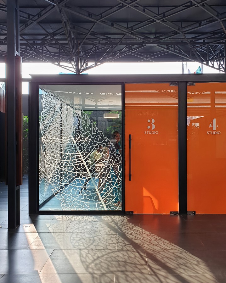 PROJECT INFORMATION Project Name: Experience Centre Location: Koyembedu, Chennai Site Area: 0.75 Acre Built-up Area: 0.20 Lac sft No of Floors: 1 Status: Completed Year of Completion:2021 Firm: CnT Architects Design Team (CnT): Amit Rastogi, Karthik P Nair, Anupama Rao Consultants: Metal Queen (Structure), Mukund Associates (Plumbing), Lite Lab (Lighting Design), Oikos (Landscape), Graphics Beyond (Graphic Design) Photography: Andre Fanthome INTRO (470 Words) Located in Chennai metropolitan at a close proximity to city’s transit hub, the site is approached from a highly buzzing Poonamalli high road. Three key components- A marketing office, an Experience centre and a Construction site office are the core of the facility. ‘‘Journey through the project reveals intricately detailed spatial sequences carefully crafted by the thoughtful blend of Architecture, Landscape and Interior design. Visual frames and experiences unfold in layers to keep the visitor captivated & intrigued throughout.’’ A landscaped plaza creating a tranquil arrival experience is first on the entry sequence; doubling up as the interface between city and the main program filtering the unwanted external buzz. At point of arrival, one gets a glimpse of Intricate roof canopy of marketing office hovering over plaza feature wall, creating a sense of mystery for what lies ahead. ‘Marketing office’ is accessed through a curved alley; meandering through lush green it guides visitors to an arrival court revealing full view of the architecture. The form; conceived as an expansive canopy floating over slender metal columns shelters many pods beneath to hold the programme. Pods contain air-conditioned spaces for the reception, gallery, media room, customer studios etc. Arranged in a free plan form, their placement defines a natural movement spine along the longitudinal axis. Intricate design of ceiling and series of skylights along the spine enriches the experience of moving through the space. The ‘Experience centre’ is accessed through a landscape buffer placed at the end of marketing office. Steps through the landscape graduate to a scaled down movement spine representing the proportions of an apartment lobby, leading to three model apartment prototypes put on display here. Placement of model apartments is juxtaposed with various semi open and open public spaces to create a very engaging and enthralling environment. Overall visitor journey is designed as two-way experience and design features are tactfully placed along the path and at important nodes to be discovered gradually and slowly. A discreetly placed entryway at the end of experience centre leads in to the ‘Construction site office’. Encouraged to see the importance given to design of spaces for the construction team; visitors are escorted right through the common area of site office arriving on to a viewing deck opening to a panoramic view of the under construction residential township which is rising up in the background. Environmental impact: Life span of facility is five years, post which it will be dismantled. Hence, majority of the structure is designed in steel for recyclability and reuse. The modular structural elements are going to be used for another project of the developer, making this project as sustainable as possible. Circulation spaces are well shaded and allow a lot of cross breezes, essential for comfort in hot humid weather of Chennai; reducing need of air conditioning to the minimum. - Sheet13