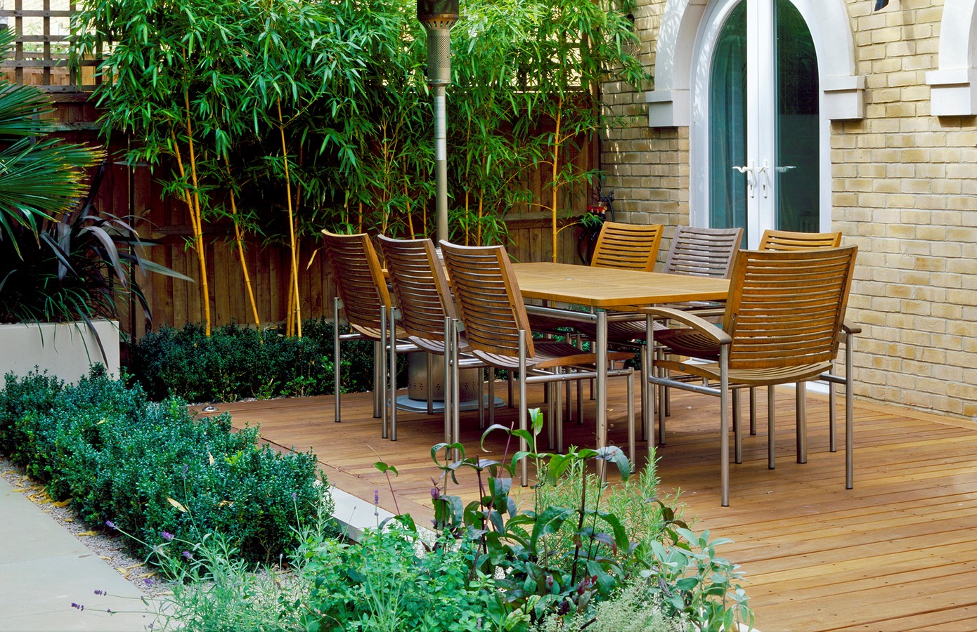 WOODEN TERRACE BESIDE HOUSE WITH TABLE AND CHAIRS PHYLLOSTACHYS VIVAX 'AUREOCALLIS' AND BOX. DESIGN : AMIR SCHLEZINGER/ MY LANDSCAPES-Sheet1